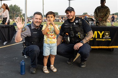 Two Des Plaines police officers pose for a photo with a young resident.